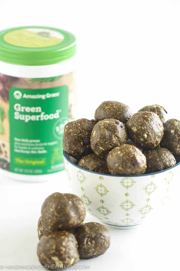 Energy bite balls in a bowl with amazing grass container in background