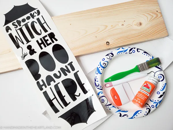 Supplies to make a wood painted Halloween sign with vinyl lettering