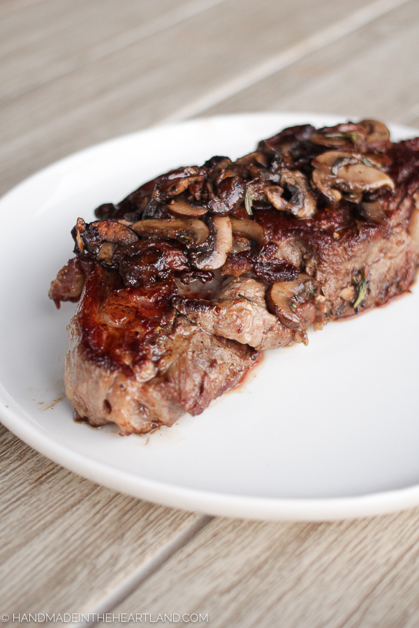 Ribeye steak with cooked mushrooms on top