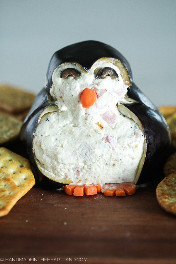 picture of cheeseball appetizer decorated to look like it's a penguin
