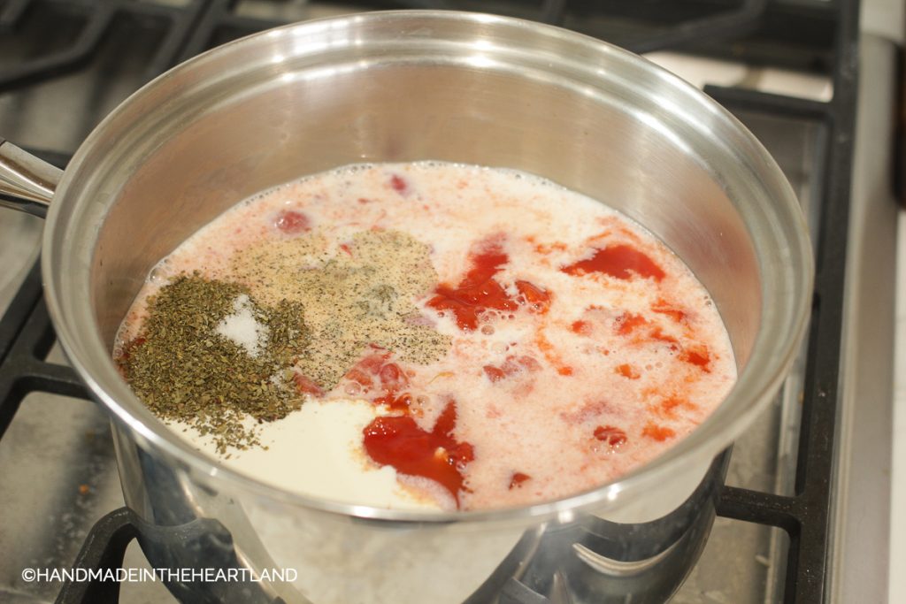 All ingredients for creamy tomato soup dumped in a stock pot