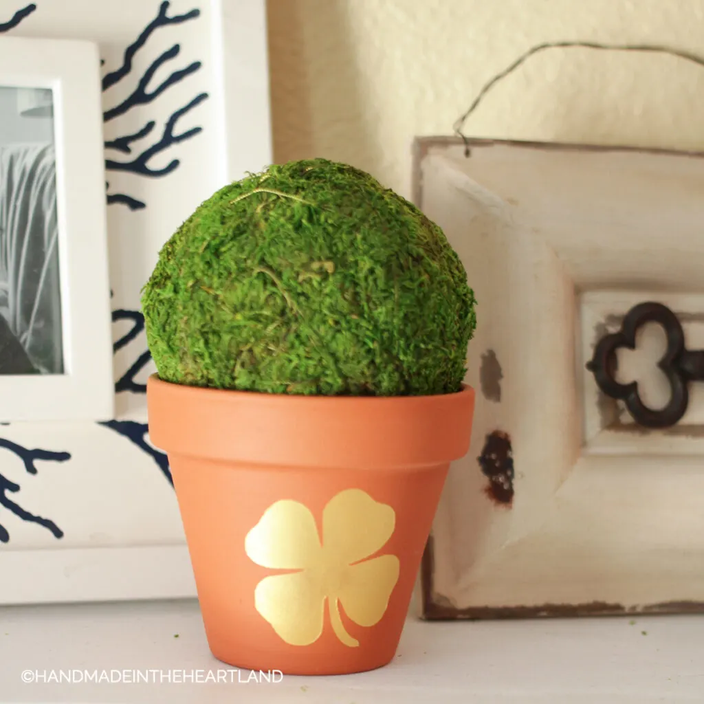 gold four leaf clover painted on terra cotta flower pot