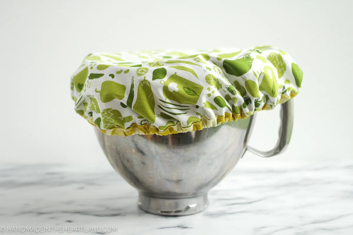 A stand mixer metal bowl covered with fabric elastic mixing bowl cover