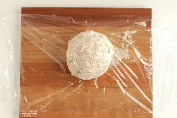cheese ball ready to be wrapped in plastic wrap