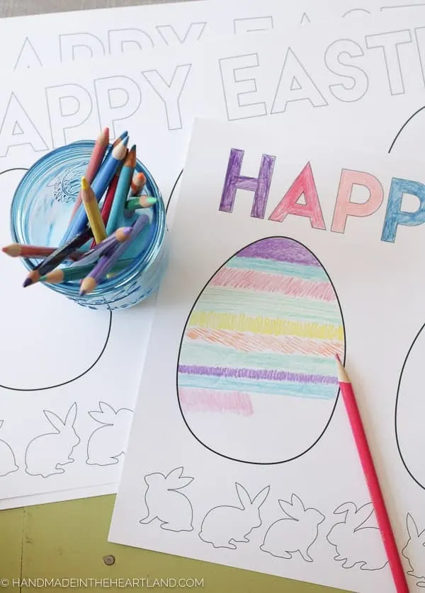 Easter egg coloring page on table with jar of colored pencils