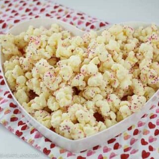 Heart shaped plate with puffcorn coated in almond bark on the plate