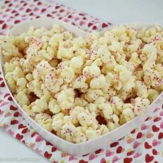 Heart shaped plate with puffcorn coated in almond bark on the plate