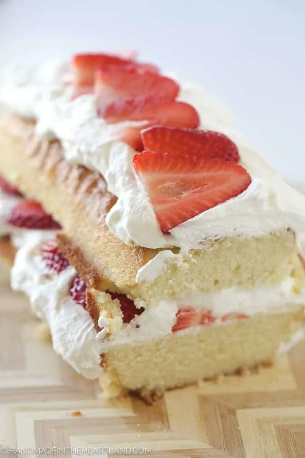 This strawberry shortcake cake recipe is an easy, simple and fresh dessert to eat all spring and summer. Layered with shortcake, strawberries and fresh whipped cream it's a delicious and light traditional strawberry shortcake. Layered strawberry shortcake cake with fresh strawberries