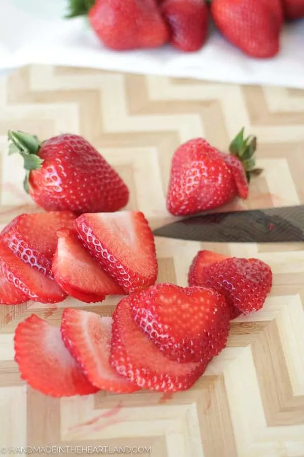 fresh strawberries sliced on cutting board