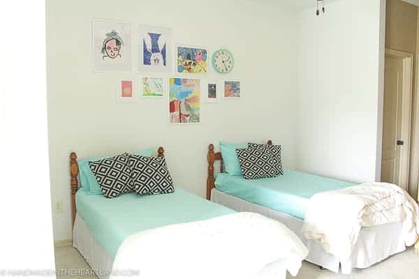 Modern kids room decor refresh after shot- showing 2 twin beds with aqua bedding and white walls with white framed kids artwork