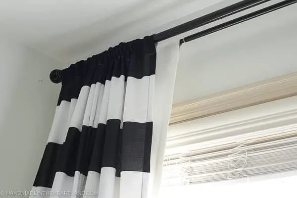 black and white striped curtains in front of blackout curtains in a modern kids room
