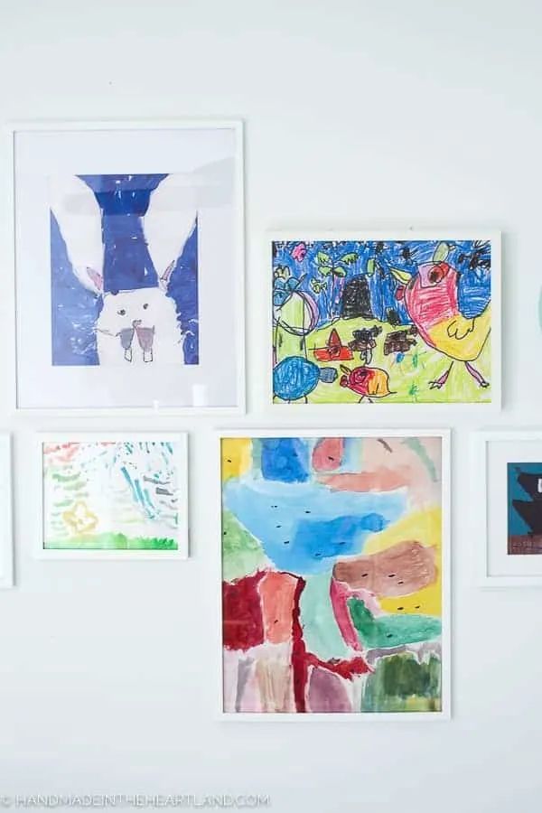kids artwork displayed in simple white frames on a white wall