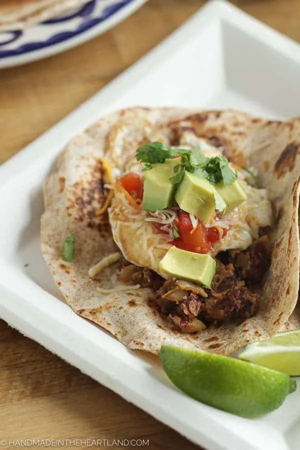 delicious breakfast tacos with red beans, fried eggs and tomatoes