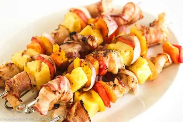Image of skewers made with bacon wrapped shrimp, pineapple and veggies