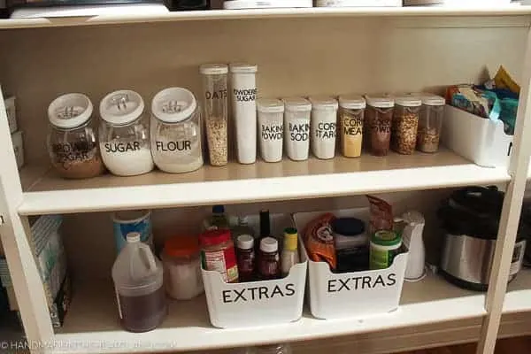 Image of nicely labeled clear containers with pantry staples such as corn starch, flour and oats. 
