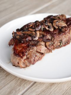 Ribeye steak with cooked mushrooms on top