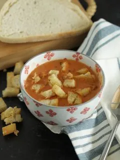 Tomato soup in a bowl with garlic parmesan sourdough croutons on top