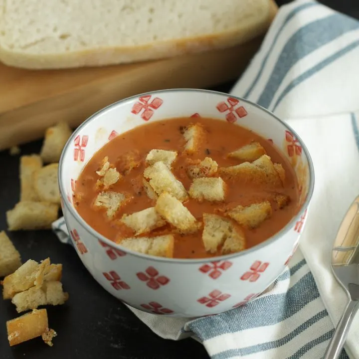 Tomato soup in a bowl with garlic parmesan sourdough croutons on top