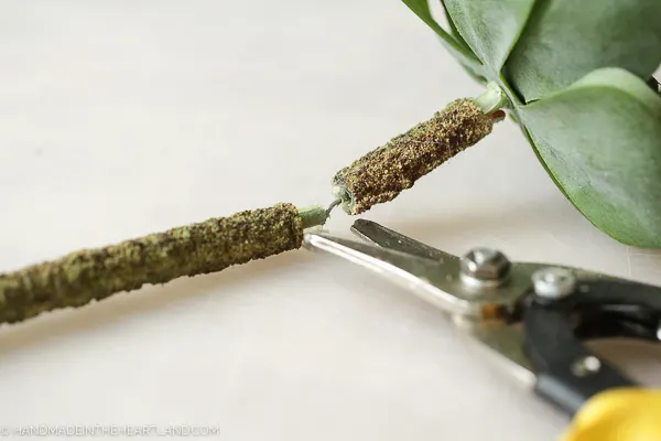 using wire cutters to cut stems of faux succulents