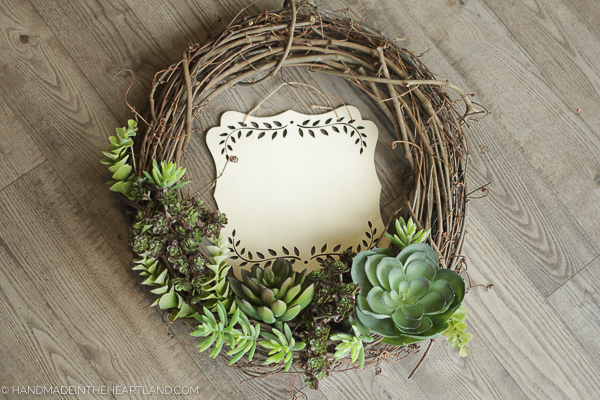 blank wood piece sitting inside the middle of a wreath