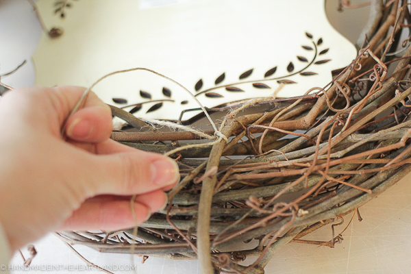 tying wood sign onto wreath