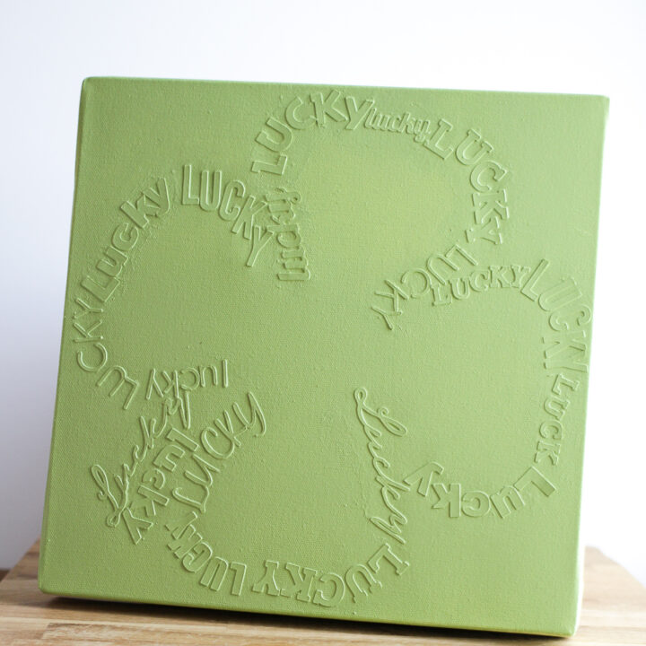 monochromatic green canvas with lucky writing in the shape of a 4 leaf clover