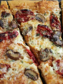 slice of pizza with mushrooms and sun-dried tomatoes