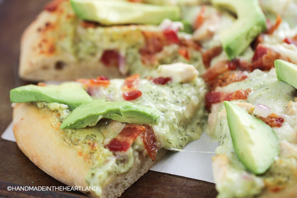 chicken bacon ranch homemade pizza sliced and sitting on a cutting board