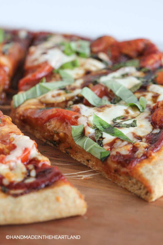 Homemade Caprese Pizza on wood cutting board