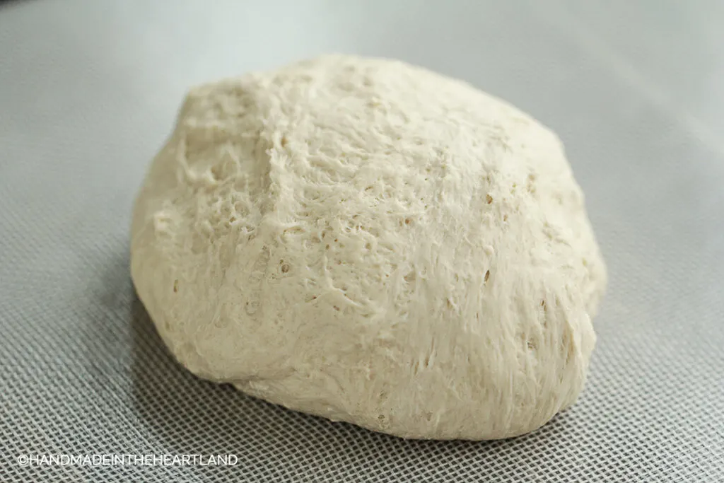 pizza dough ball sitting on nonstick mat