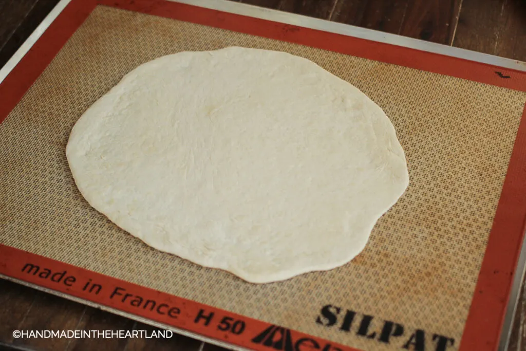 Pizza dough moved to Silpat nonstick baking liner