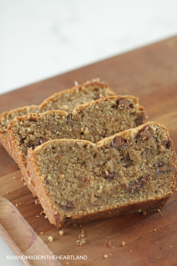 3 slices of peanut butter banana bread on wood cutting board