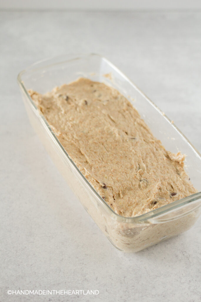 peanut butter chocolate chip banana bread loaf batter in glass pan before being baked