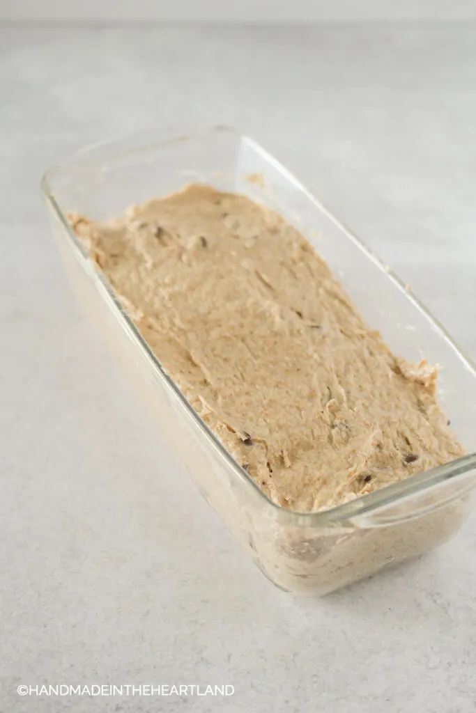 peanut butter chocolate chip banana bread loaf batter in glass pan before being baked