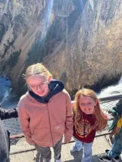 four kids at the brink of lower falls viewing point at the bottom of the trail in Yellowstone