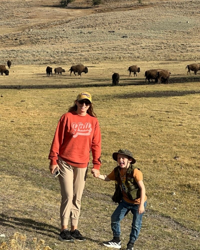 Mom and son in front of a herd of buffalo in Yellowstone